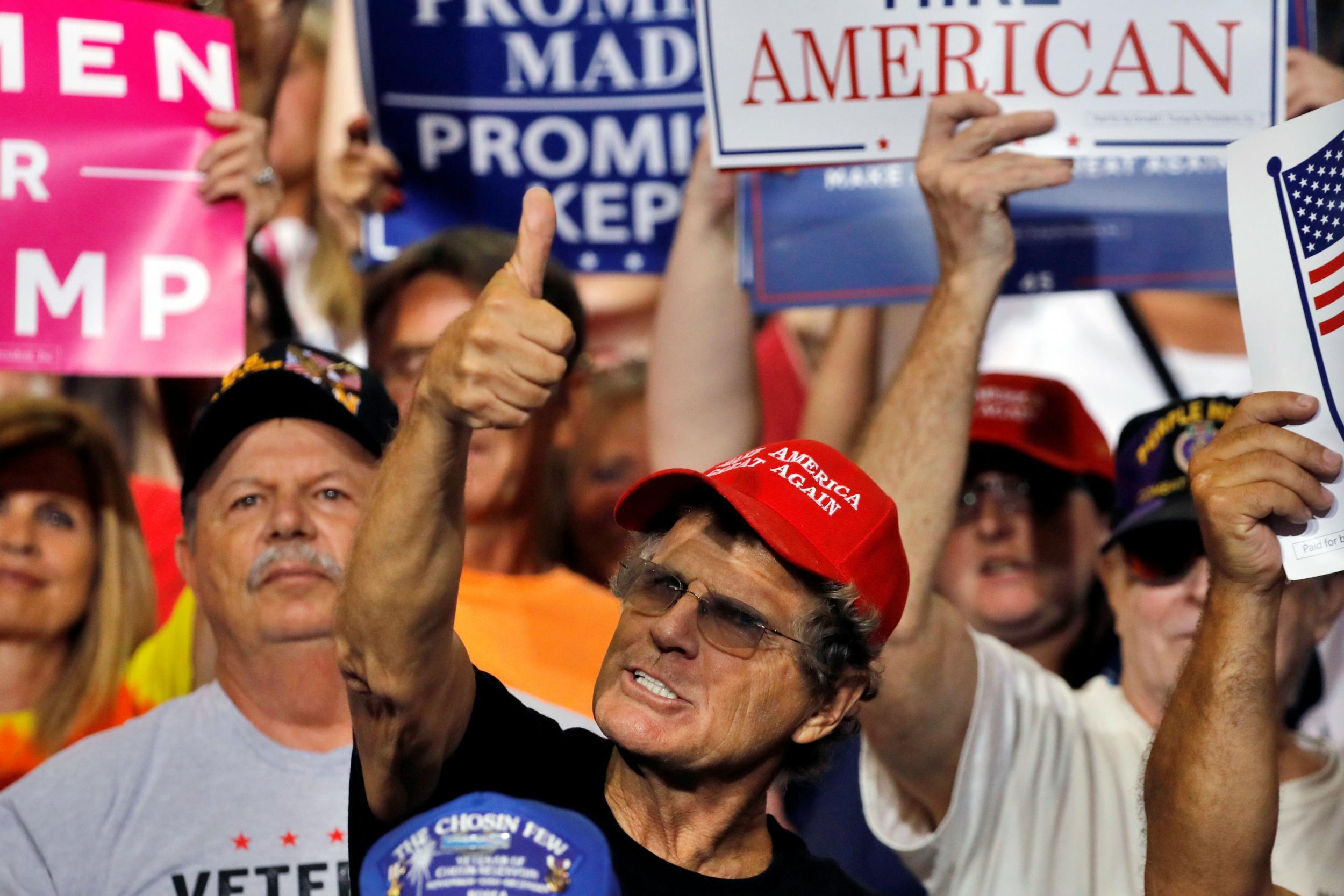 Trump supporters react at a rally after he accuses people of 'fabricating' information about him