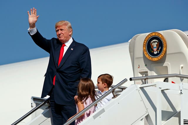 Donald Trump waves as he walks down the steps of Air Force One