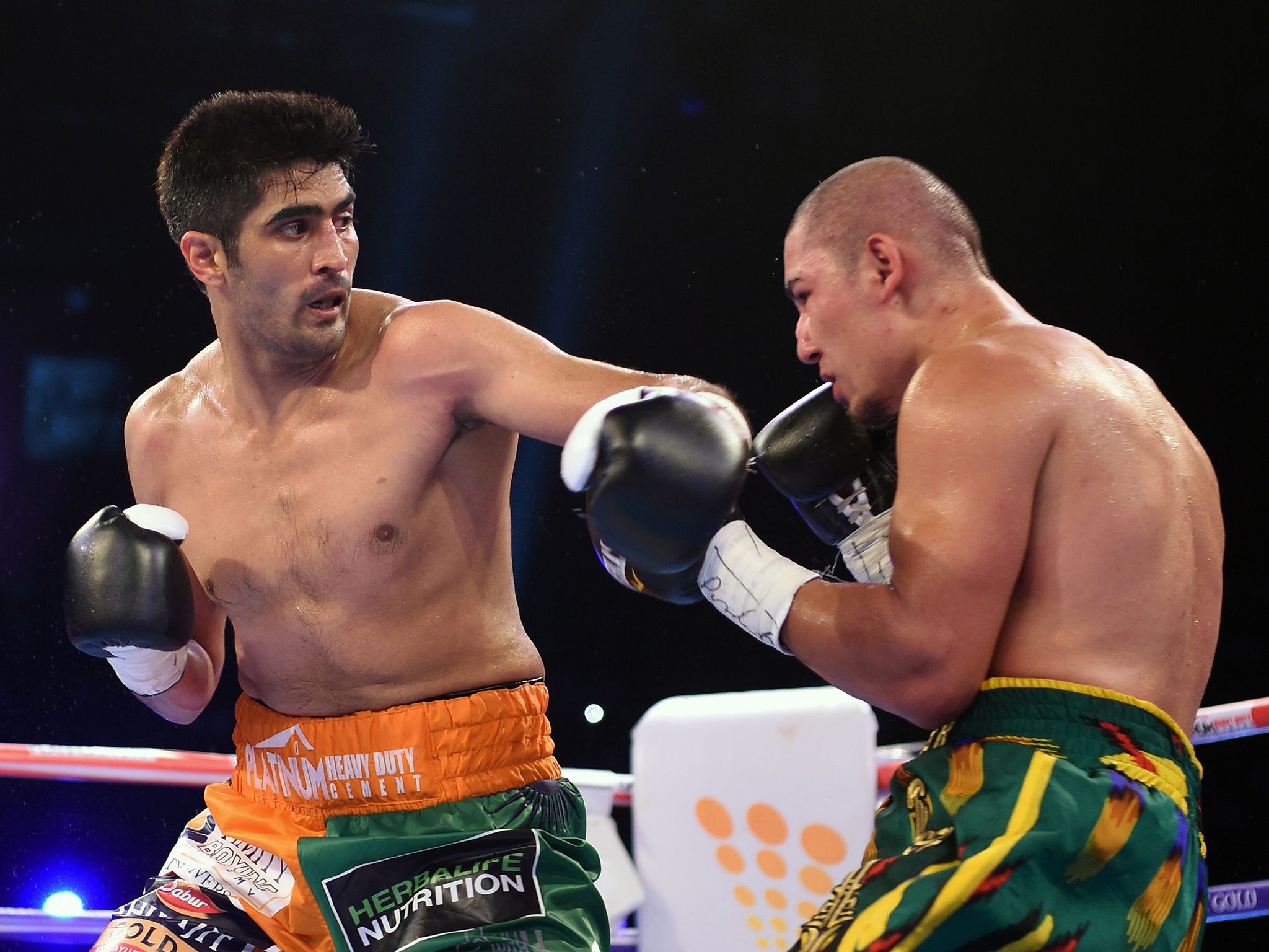 Indian boxer and WBO Asia-Pacific Super Middleweight champion Vijender Singh (L) throws a punch at WBO Oriental Super Middleweight champion of China Zulpikar Maimaitiali during their double title bout at the National Sports Complex of India (NSCI) Dome in Mumbai on August 5, 2017. / AFP PHOTO / PUNIT PARANJPEPUNIT PARANJPE/AFP/Getty Images (AFP )