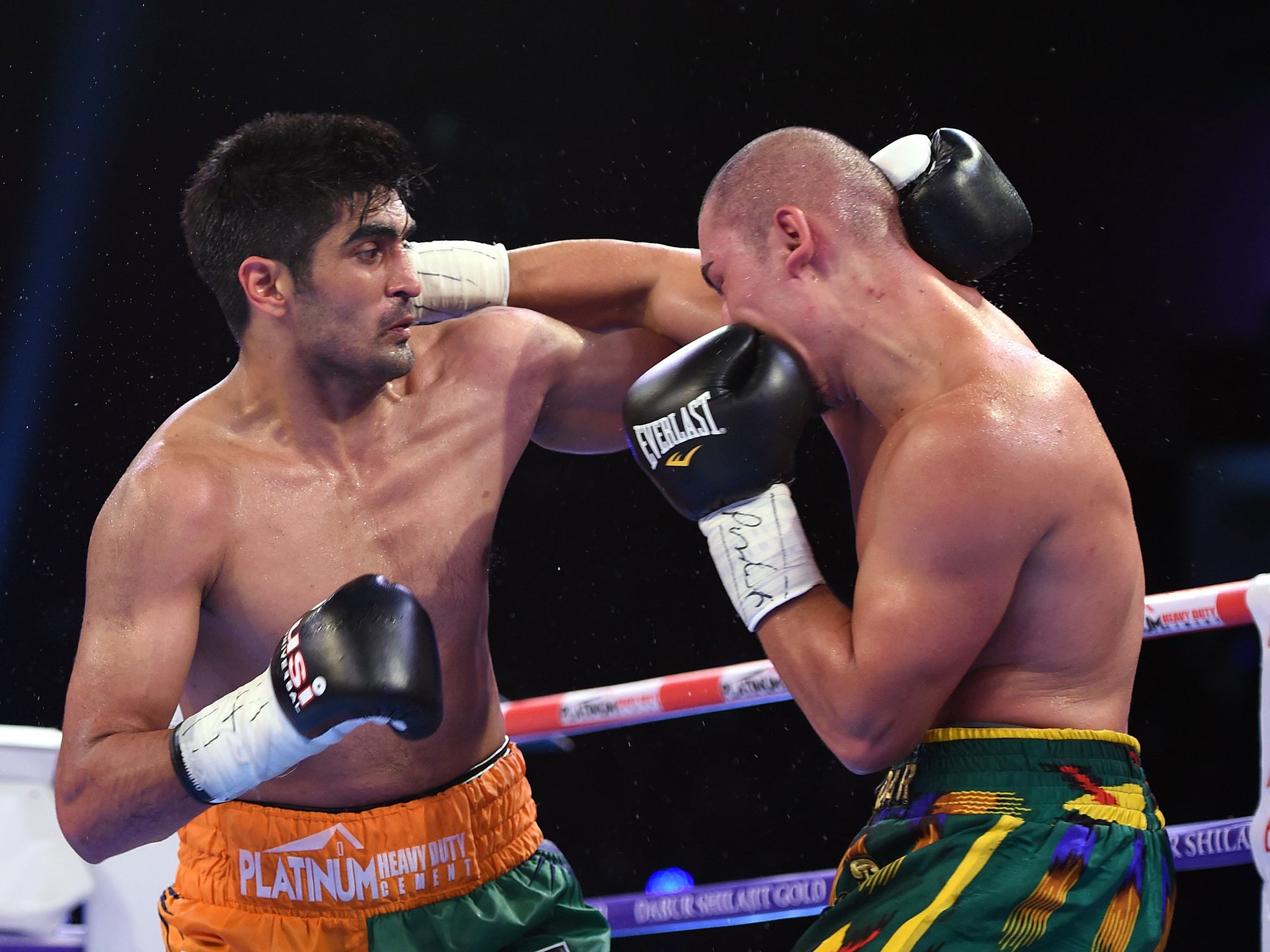 Indian boxer and WBO Asia-Pacific Super Middleweight champion Vijender Singh (L) throws a punch at WBO Oriental Super Middleweight champion of China Zulpikar Maimaitiali during their double title bout at the National Sports Complex of India (NSCI) Dome in Mumbai on August 5, 2017. / AFP PHOTO / PUNIT PARANJPEPUNIT