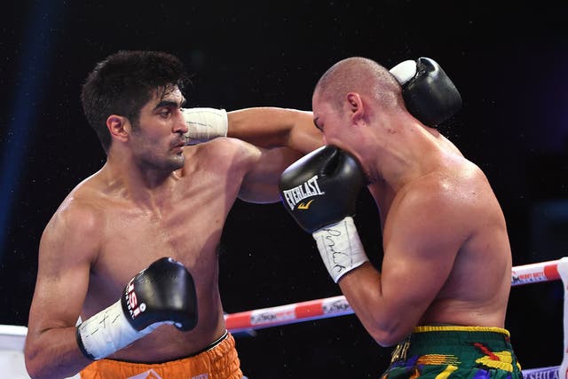 Indian boxer and WBO Asia-Pacific Super Middleweight champion Vijender Singh (L) throws a punch at WBO Oriental Super Middleweight champion of China Zulpikar Maimaitiali during their double title bout at the National Sports Complex of India (NSCI) Dome in Mumbai on August 5, 2017. / AFP PHOTO / PUNIT PARANJPEPUNIT