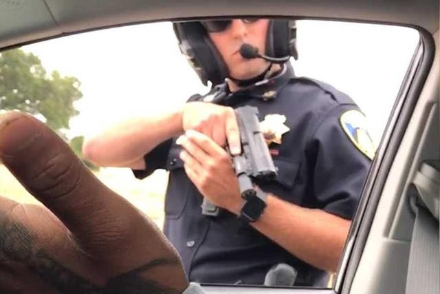A still from a video apparently recorded by a woman in the car as the male passenger expresses incredulity the officer has drawn his gun