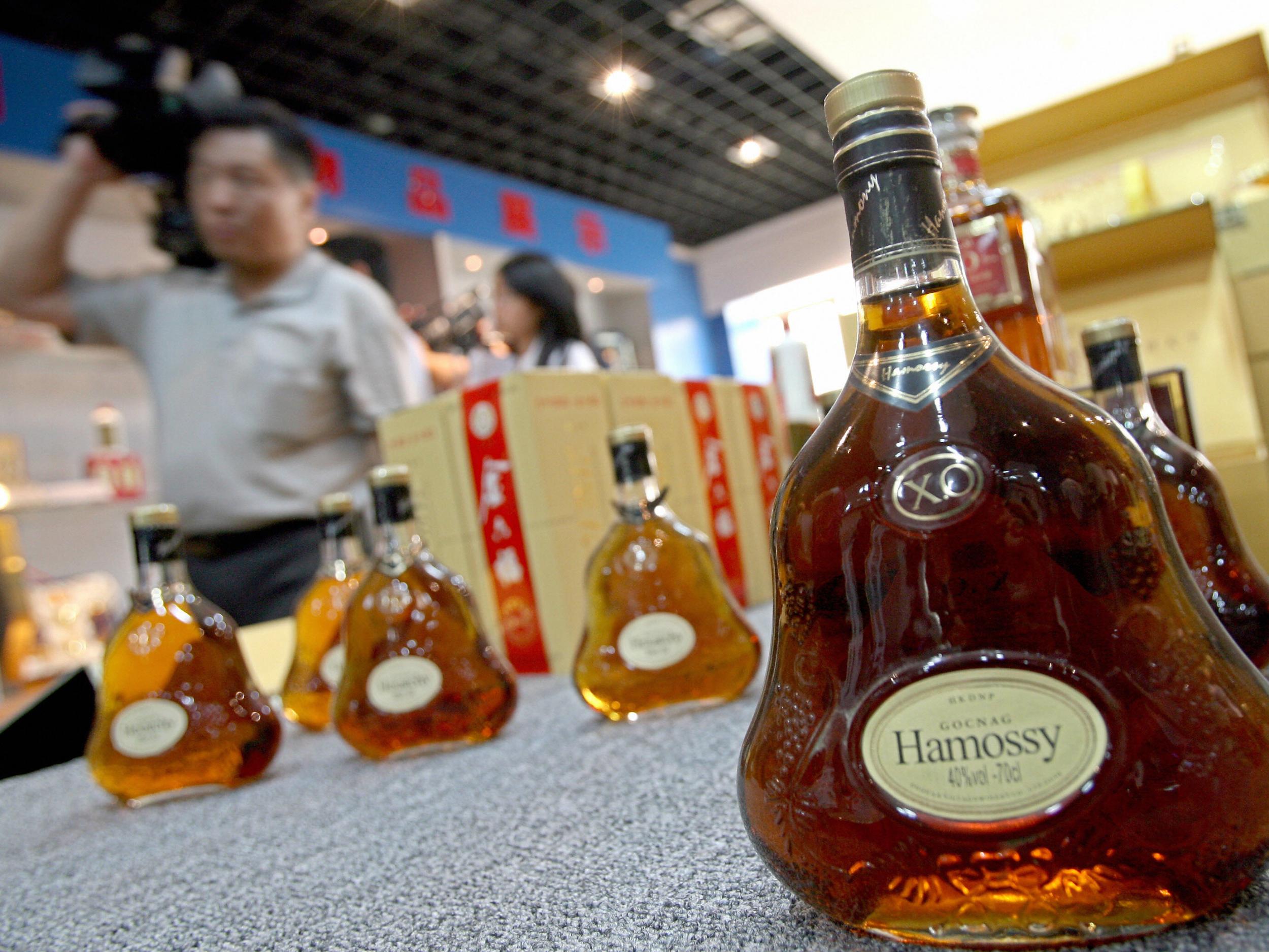 Visitors walk past counterfeit liquor on display at the Beijing administration for industry and commerce center for food safety test in Beijing