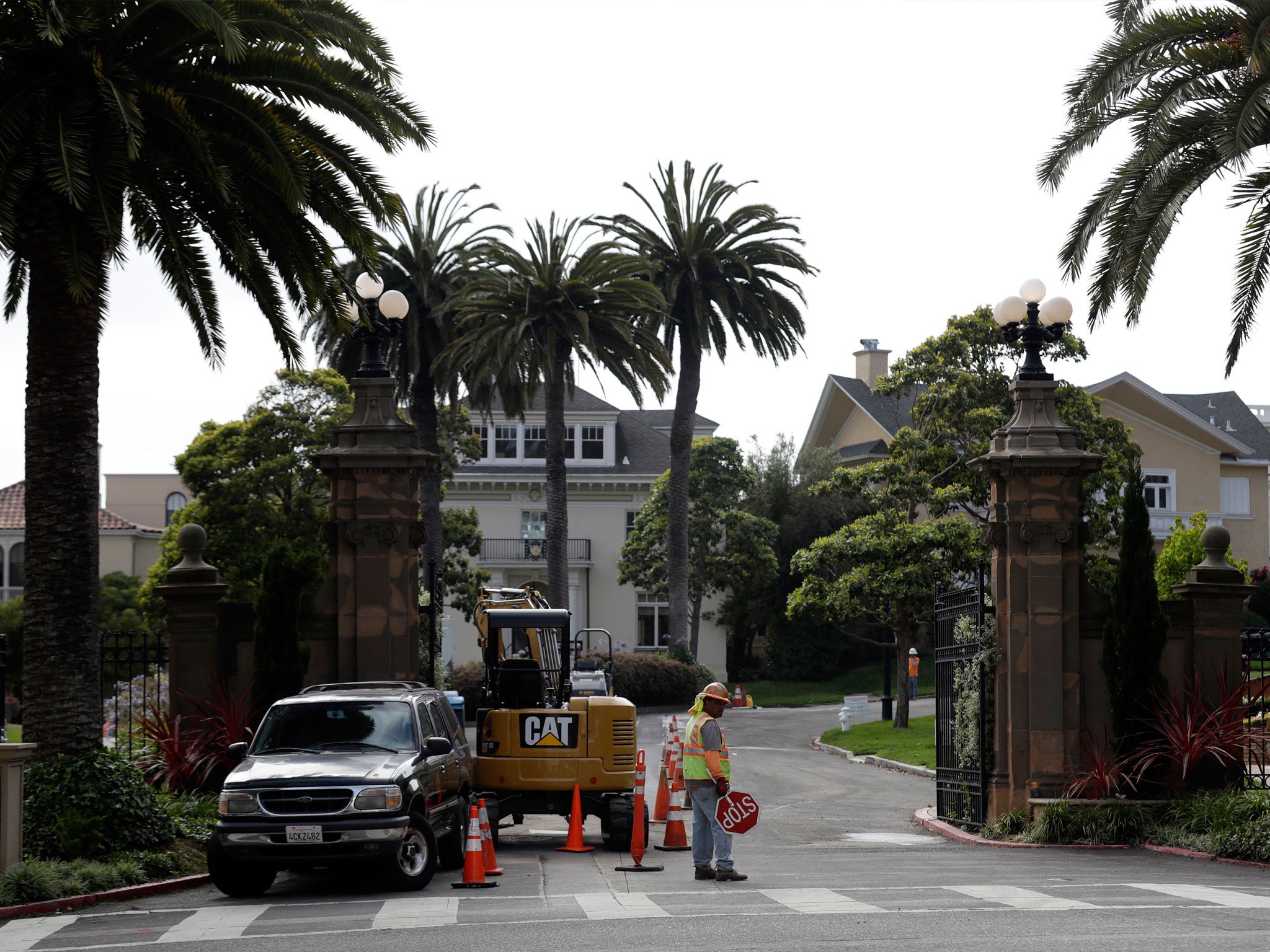 A construction worker stands in front of a gate leading into the Presidio Terrace
