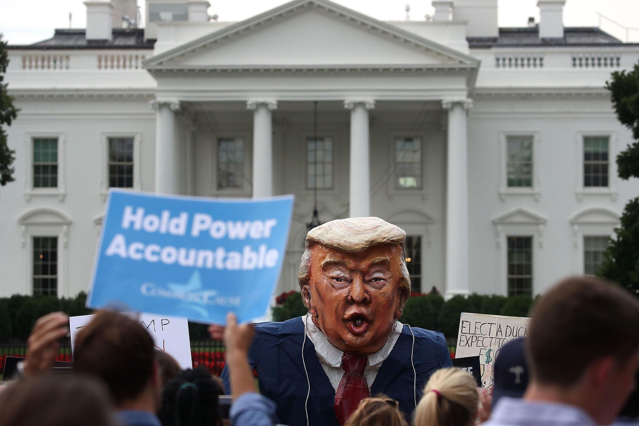 People protest against President Donald Trump in front of the White House on July 11, 2017
