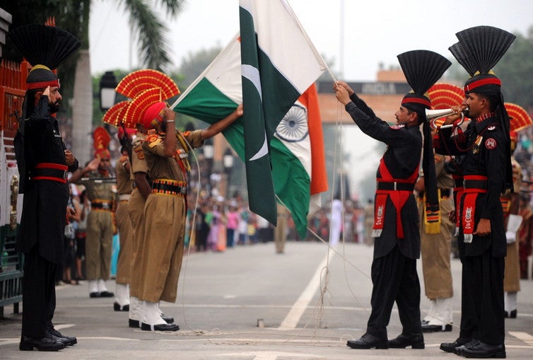 Pakistani rangers (in black) and Indian security forces lower their flags during a ceremony at the Wagah border with India, near Lahore, in 2011