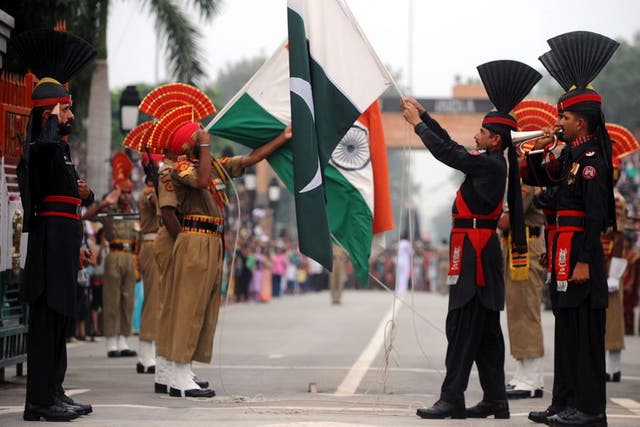 Pakistani rangers (in black) and Indian security forces lower their flags during a ceremony at the Wagah border with India, near Lahore, in 2011