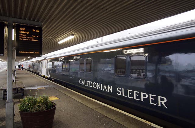 A Caledonian Sleeper train sits on a platform
