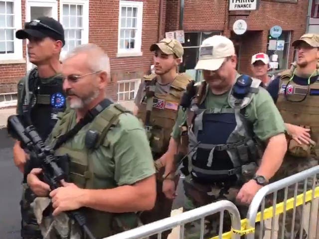 Apparent militia members carrying assault rifles and other weapons march through Charlottesville, Virginia