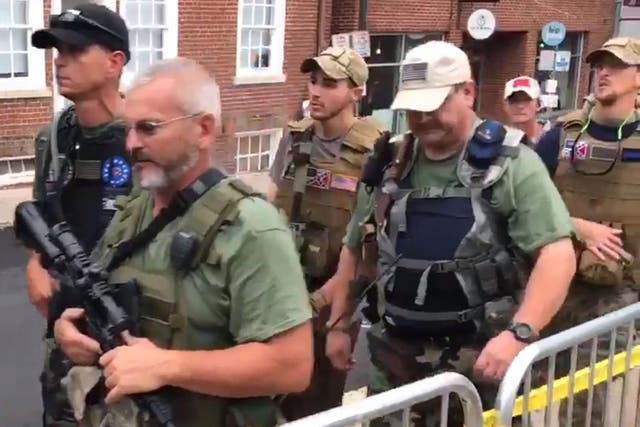 Apparent militia members carrying assault rifles and other weapons march through Charlottesville, Virginia