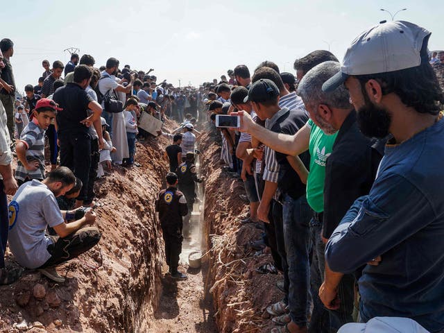 Members of the Syrian civil defence volunteers, also known as the White Helmets, bury their fellow comrades during a funeral in Sarmin, a jihadist-held town nine kilometres east of Syria's northwestern city of Idlib on August 12, 2017, after seven were shot dead early in the morning during a raid on their base, according to the organisation.
The Syrian Observatory for Human Rights said the seven volunteers had all been killed by bullets to the head.
"Two minibuses, some white helmets and walkie-talkies were stolen," the White Helmets said in statement. It was not immediately clear whether the robbery or the murders were the primary motive for the raid. / AFP PHOTO / OMAR HAJ KADOUROMAR HAJ KADOUR/AFP/Getty Images