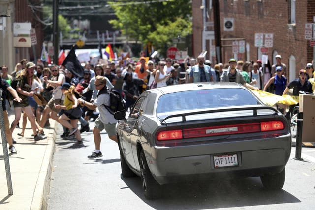 People flee as a car drives towards protesters in Charlottesville, Virginia