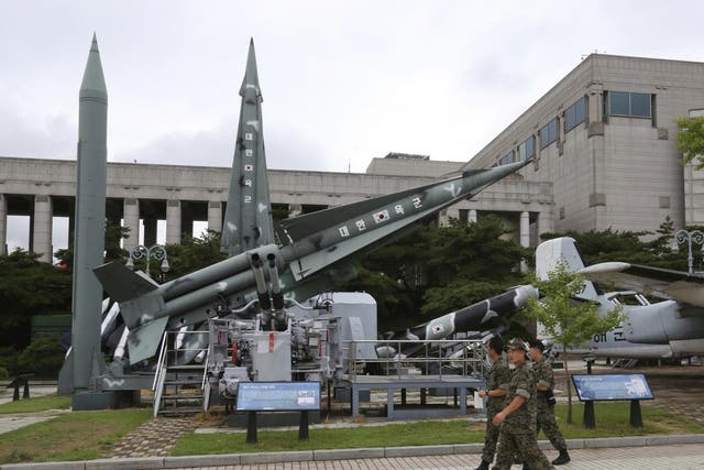 South Korean army soldiers walk by a mock Scud-B missile of North Korea
