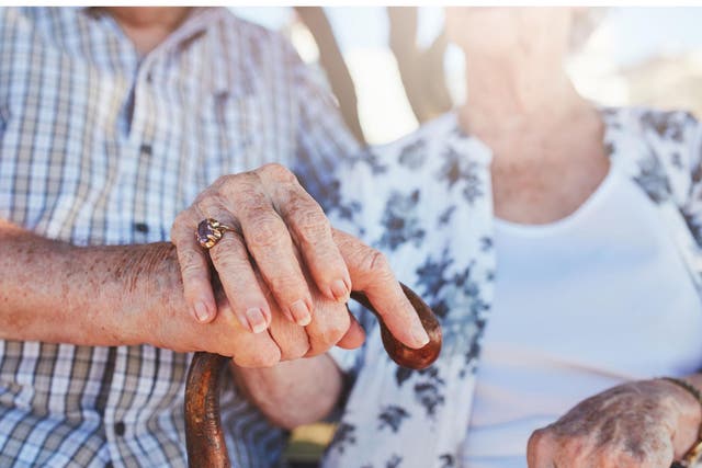 Stock image of elderly couple holding hands