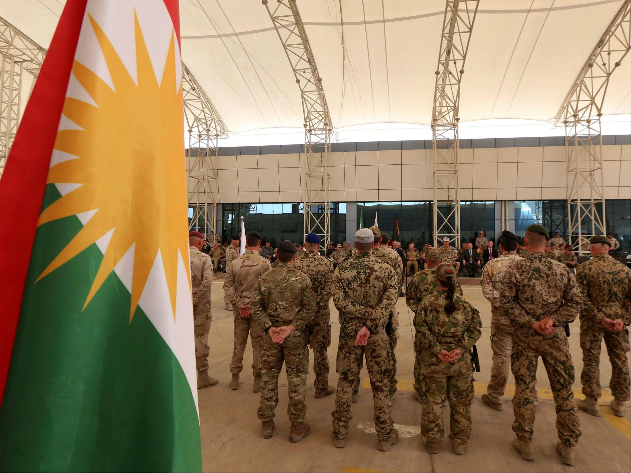 Military advisers from the international coalition forces stand during a transfer of authority ceremony on 15 June 2017 at the Kurdistan Training Coordination Center (KTTC) of Erbil, the capital of the autonomous Kurdish region of northern Iraq.