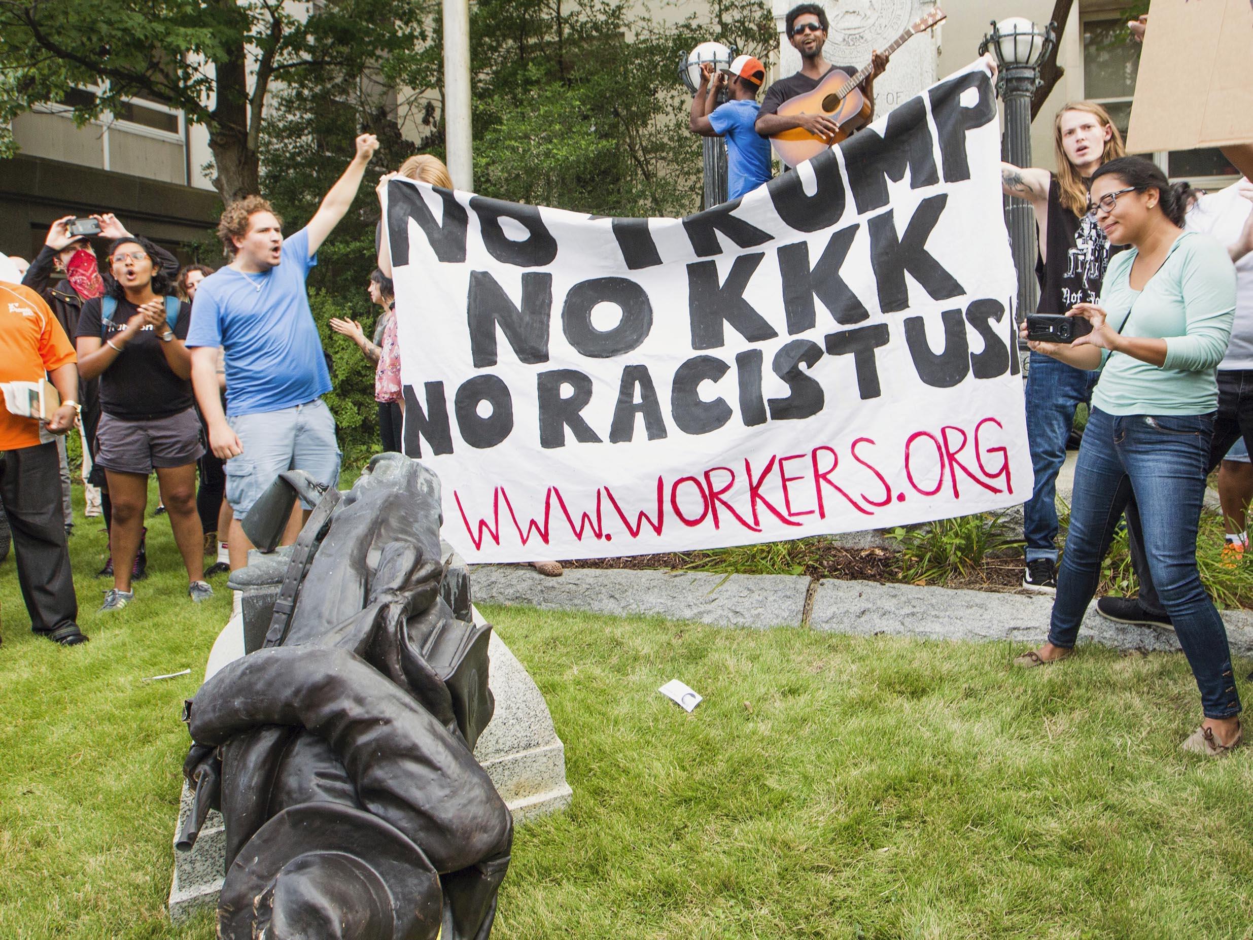 Protesters celebrate after toppling a statue of a Confederate solder in Durham, North Carolina, on 14 August 2017