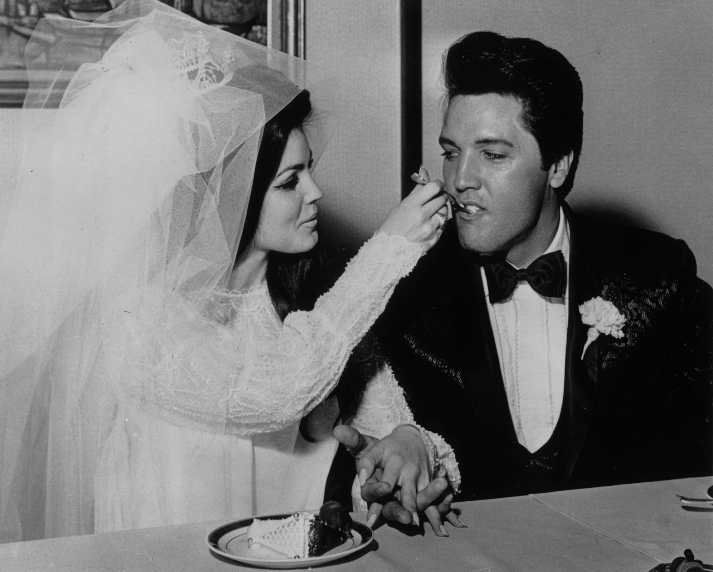 Elvis Presley being fed a mouthful of wedding cake by his bride Priscilla Beaulieu