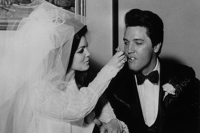 Elvis Presley being fed a mouthful of wedding cake by his bride Priscilla Beaulieu