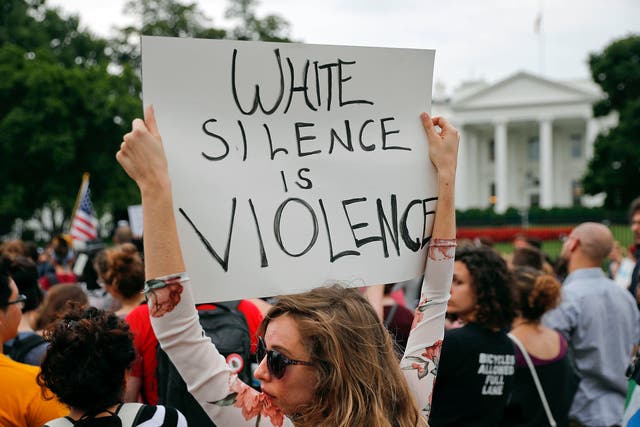 A protester holds up a sign outside the White House in response to the Charlottesville protests