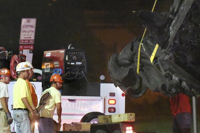 Workers in Baltimore are pictured removing a Confederate monument there