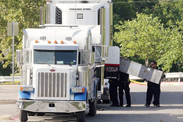 Police officers working at the crime scene after 10 people believed to be illegal immigrants being smuggled into the United States were found dead inside a sweltering 18-wheeler trailer parked behind a Walmart store in San Antonio, Texas, on 23 July 2017
