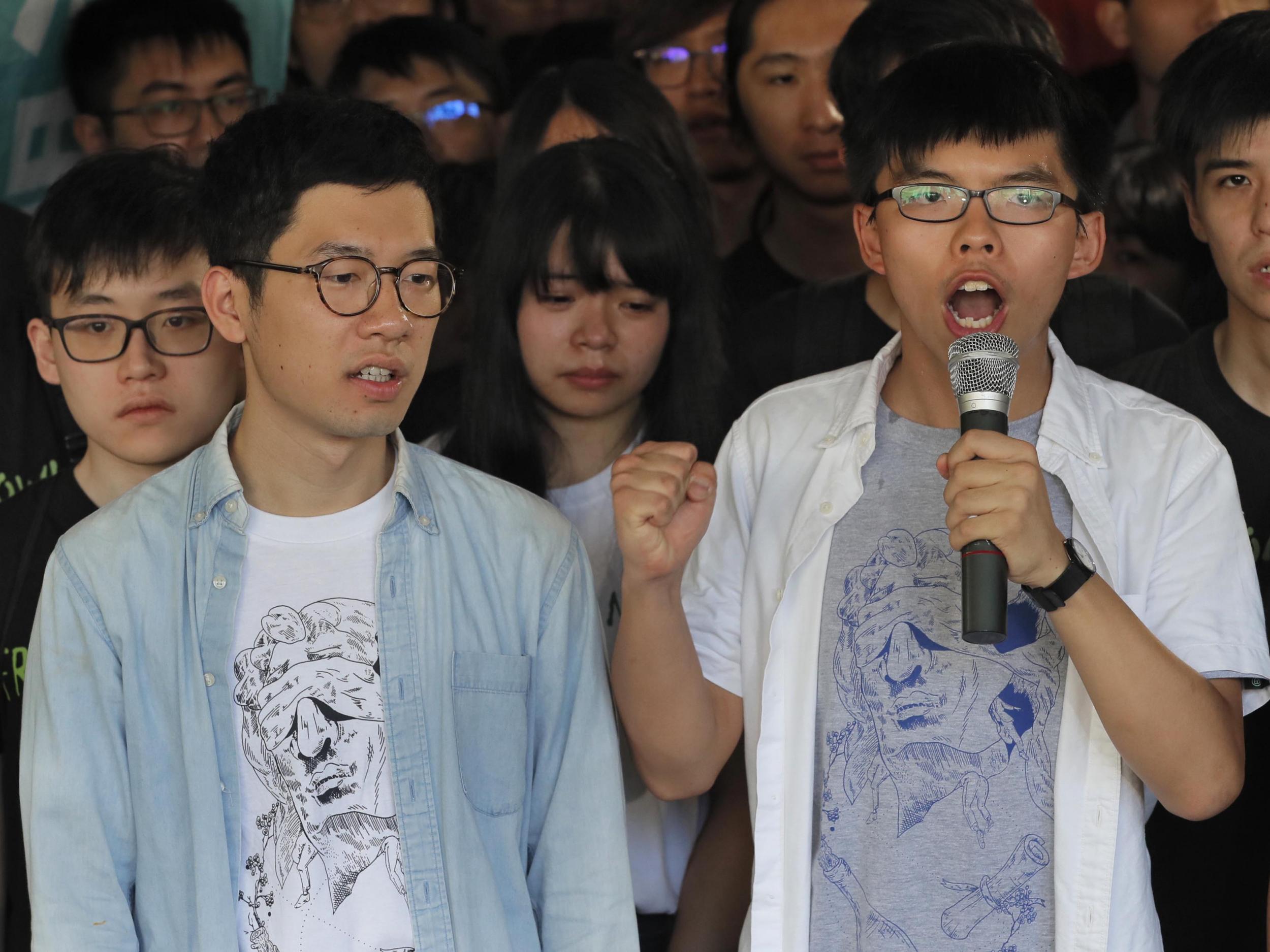 Hong Kong activists Joshua Wong, right, and Nathan Law, left, speak outside the high court before a ruling on a prosecution request for stiffer sentences following a lower court decision that let them avoid prison in Hong Kong o 17 August 2017