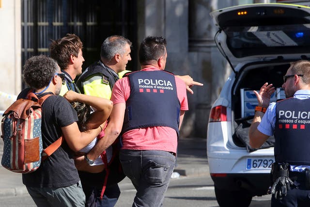 An injured person is carried in Barcelona after a white van jumped the sidewalk in the historic Las Ramblas district