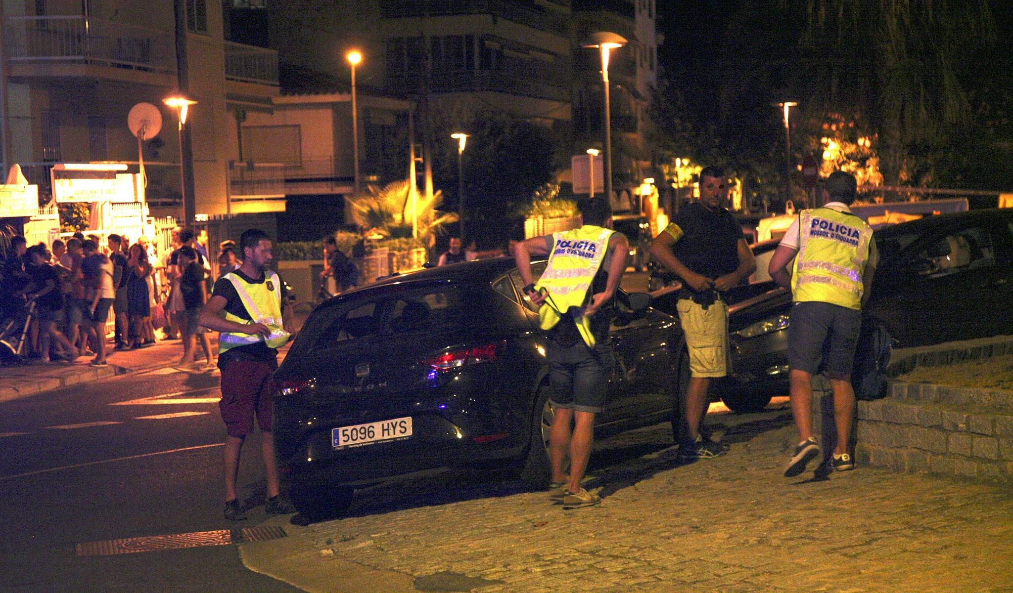 Spanish Policemen inspect a car after four suspected terrorists were killed by the police after they knocked down six civilians with their car at Paseo Maritimo in Cambrils