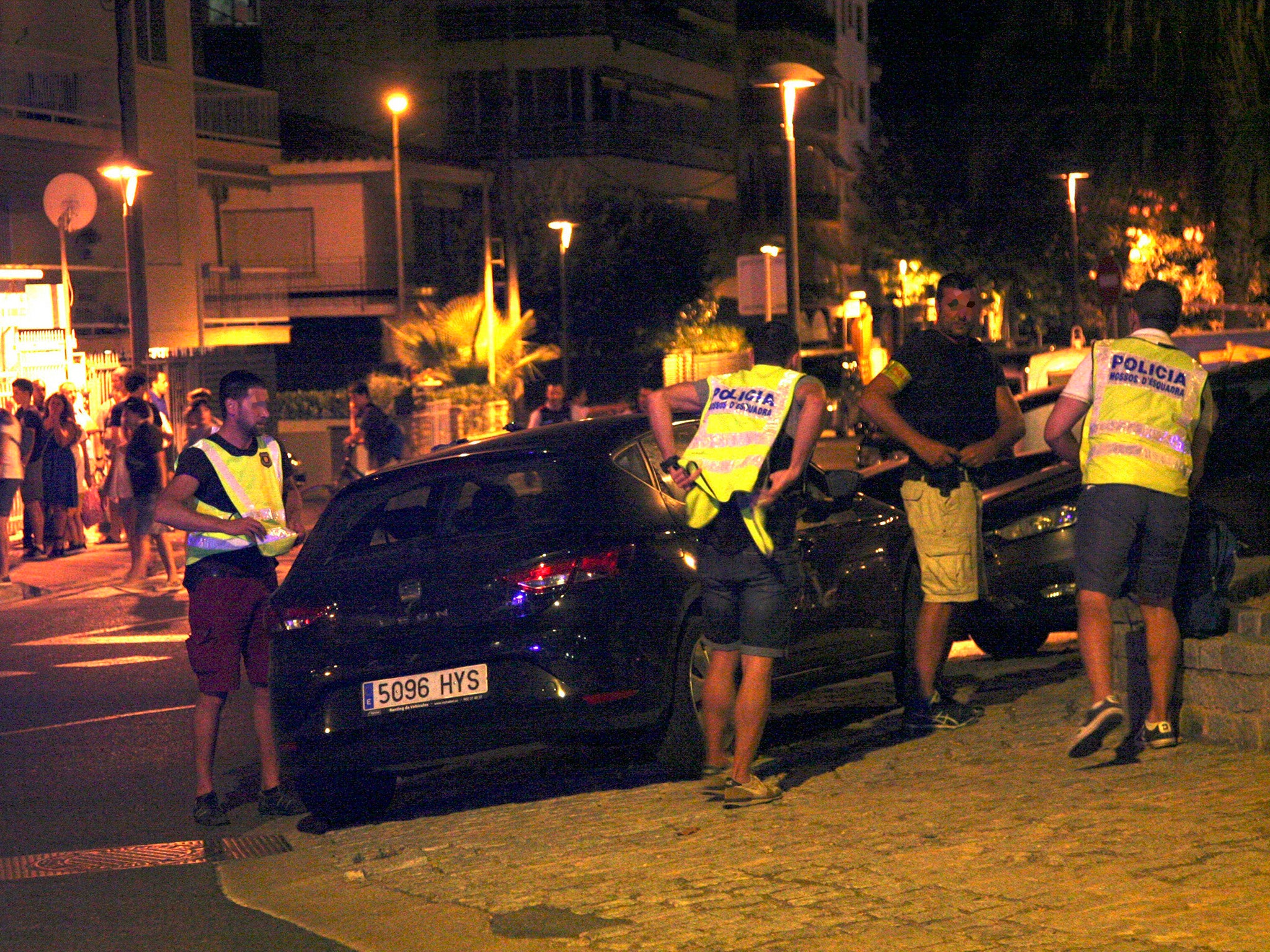 Spanish police inspect a car after suspected terrorists knocked down six civilians with their car at Paseo Maritimo in Cambrils
