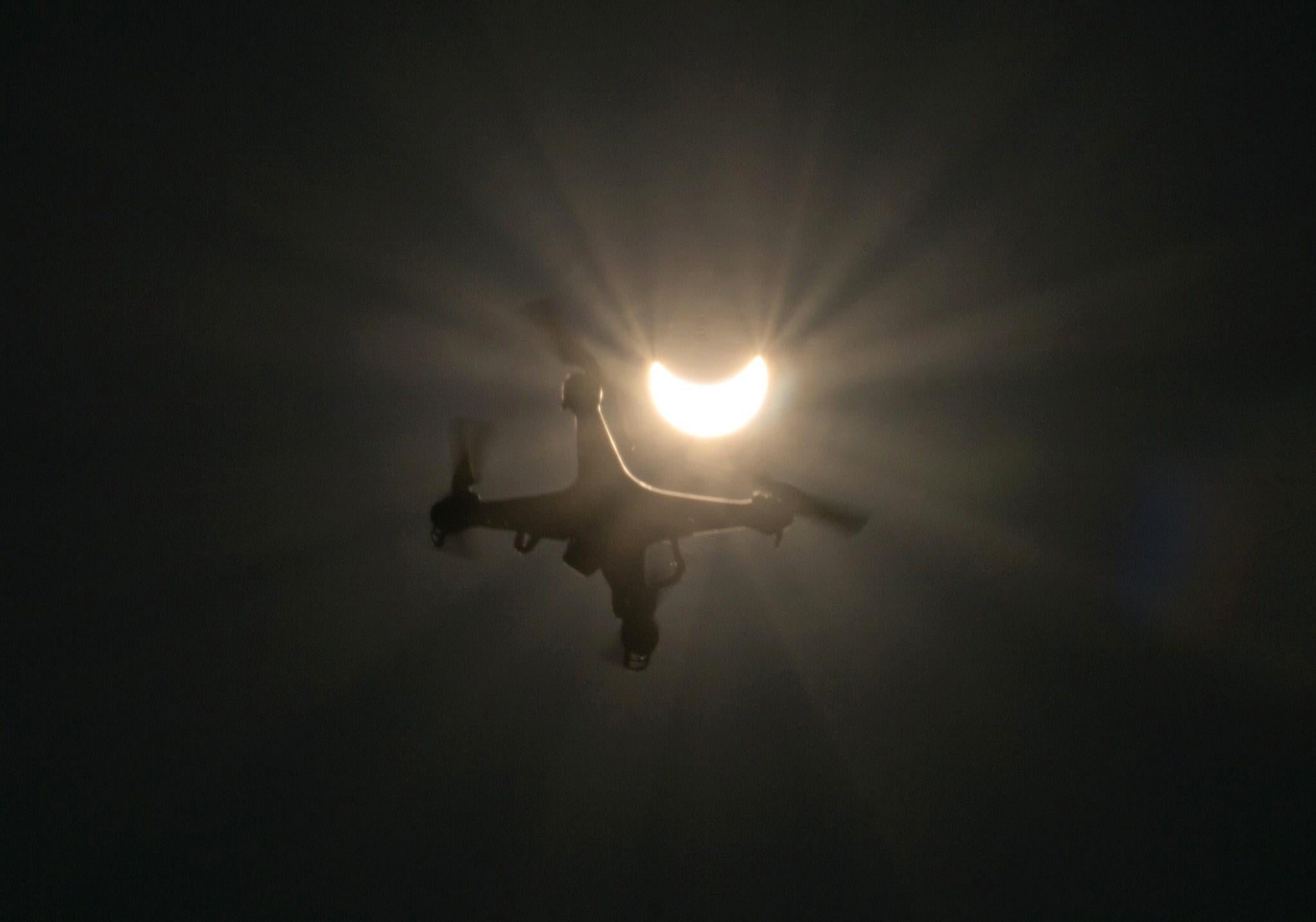 A drone flies in foreground of a partial solar eclipse in Vienna