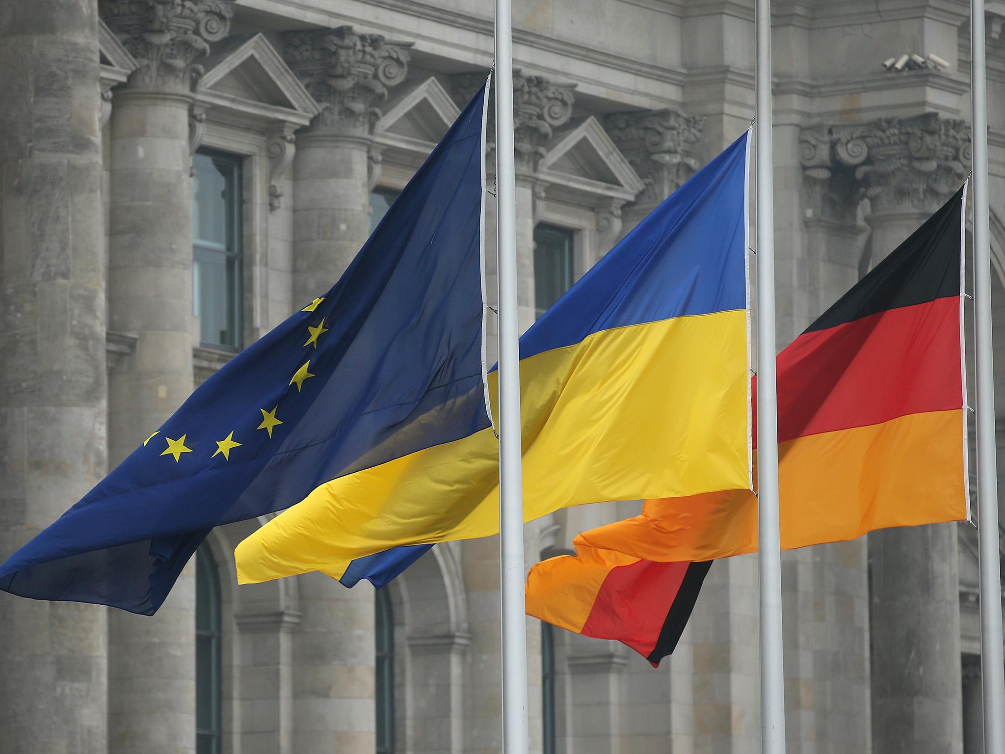 The flags of the European Union, Ukraine and Germany fly next to the Reichstag in Berlin