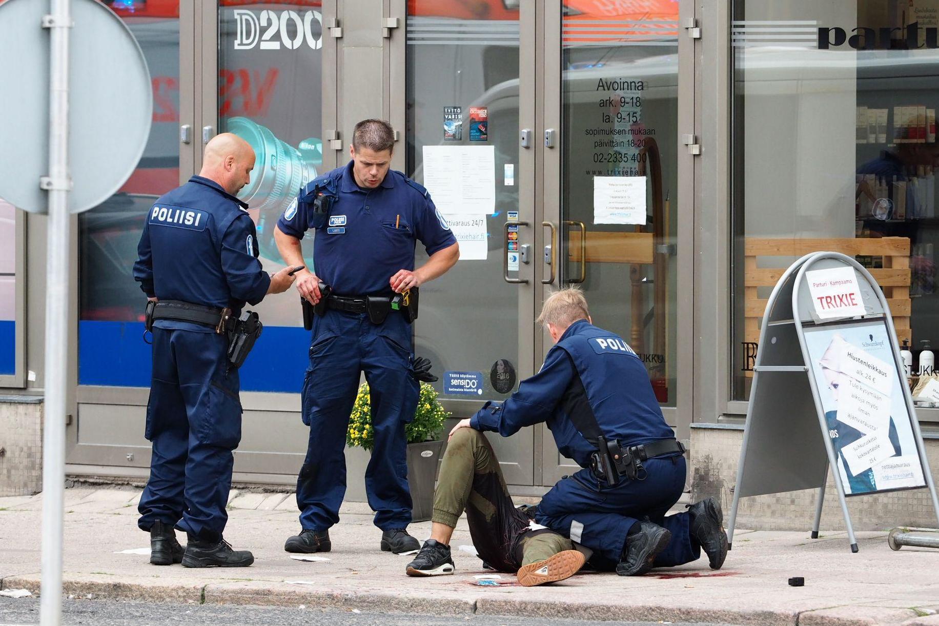 &#13;
Police officers tend to an injured person in Turku &#13;