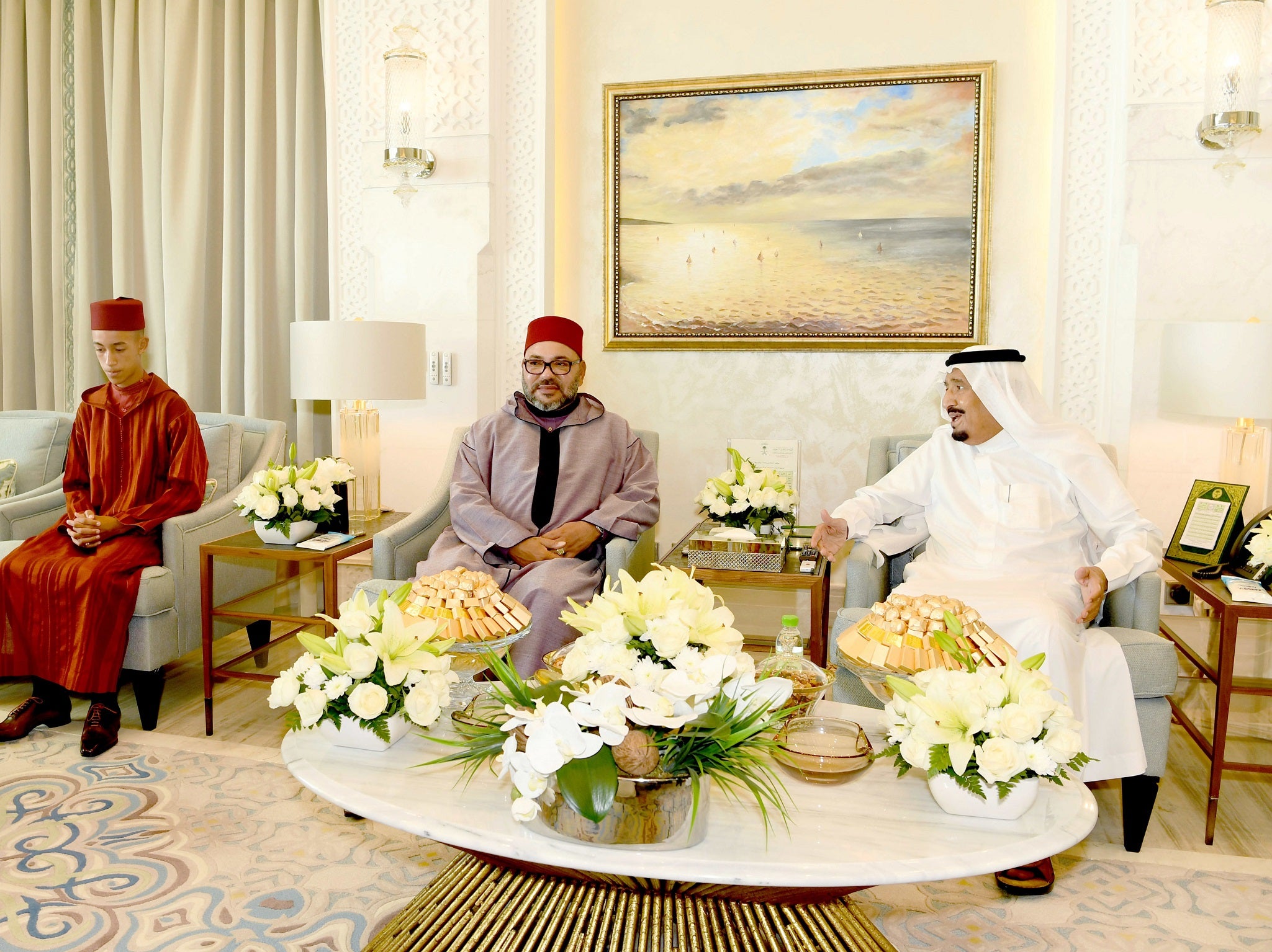 King Mohammed VI, center, is flanked by the Crown Prince Moulay Hassan, left, during a courtesy visit to Saudi King Salman in his residence in Tangier, northern Morocco