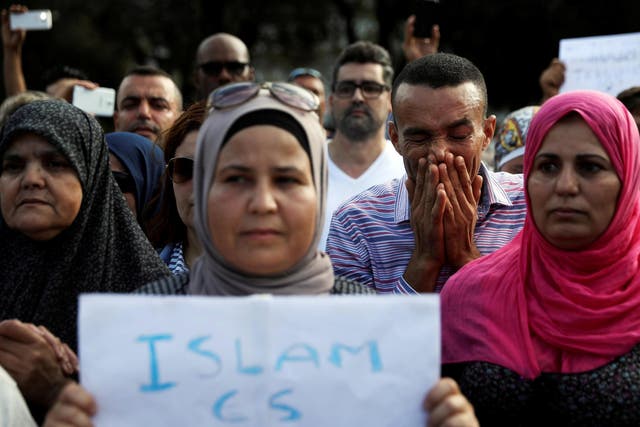 Members of Barcelona's Muslim community observe a minute's silence during a gathering to denounce terrorism near the area where a van crashed into pedestrians at Las Ramblas. The sign reads: 'Islam is peace'