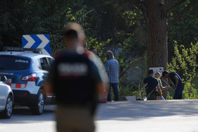 Spanish policemen check the site where Younes Abouyaaqoub was shot