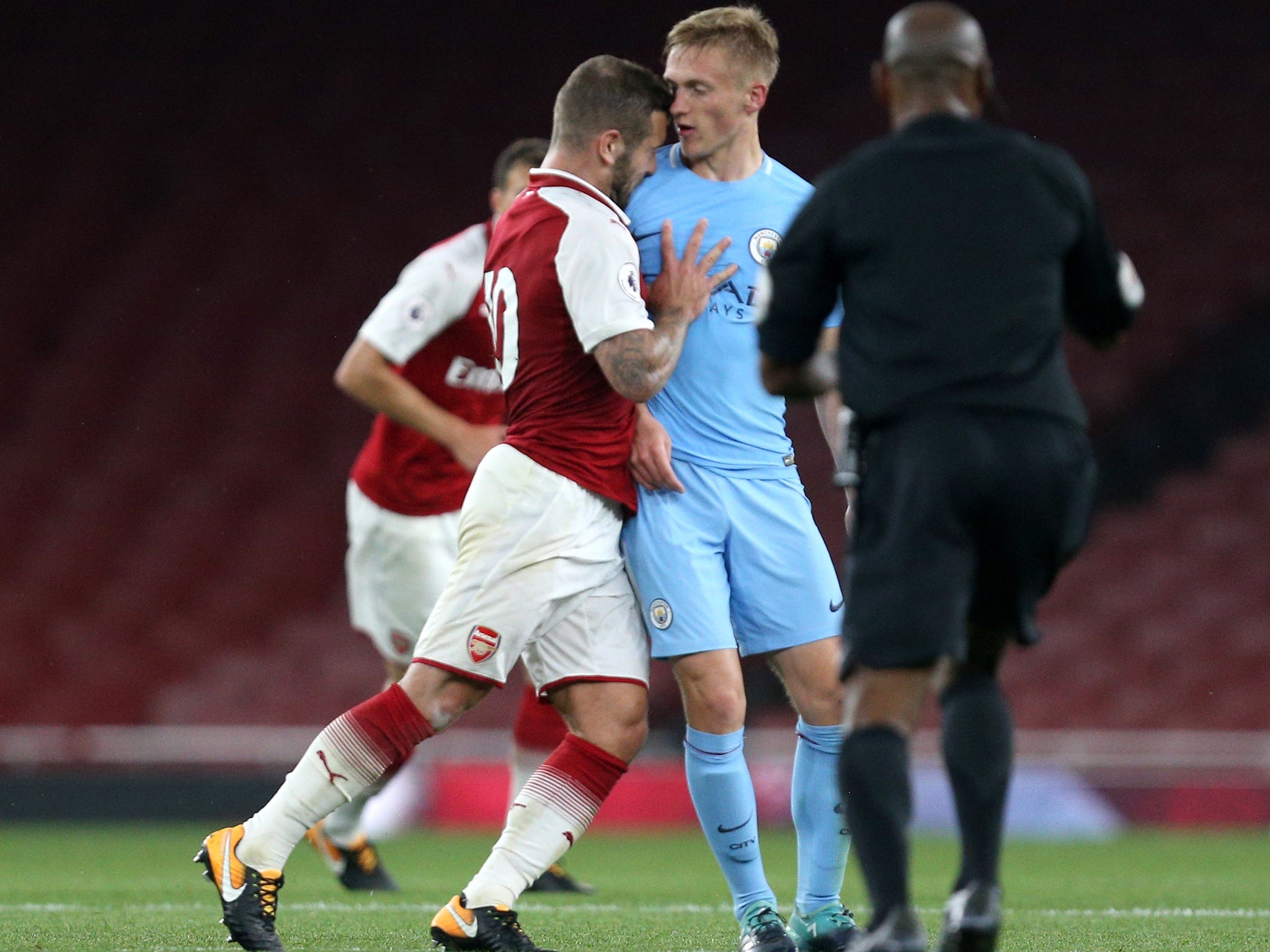 Wilshere thrusts his head into Smith after reacting badly to the tackle