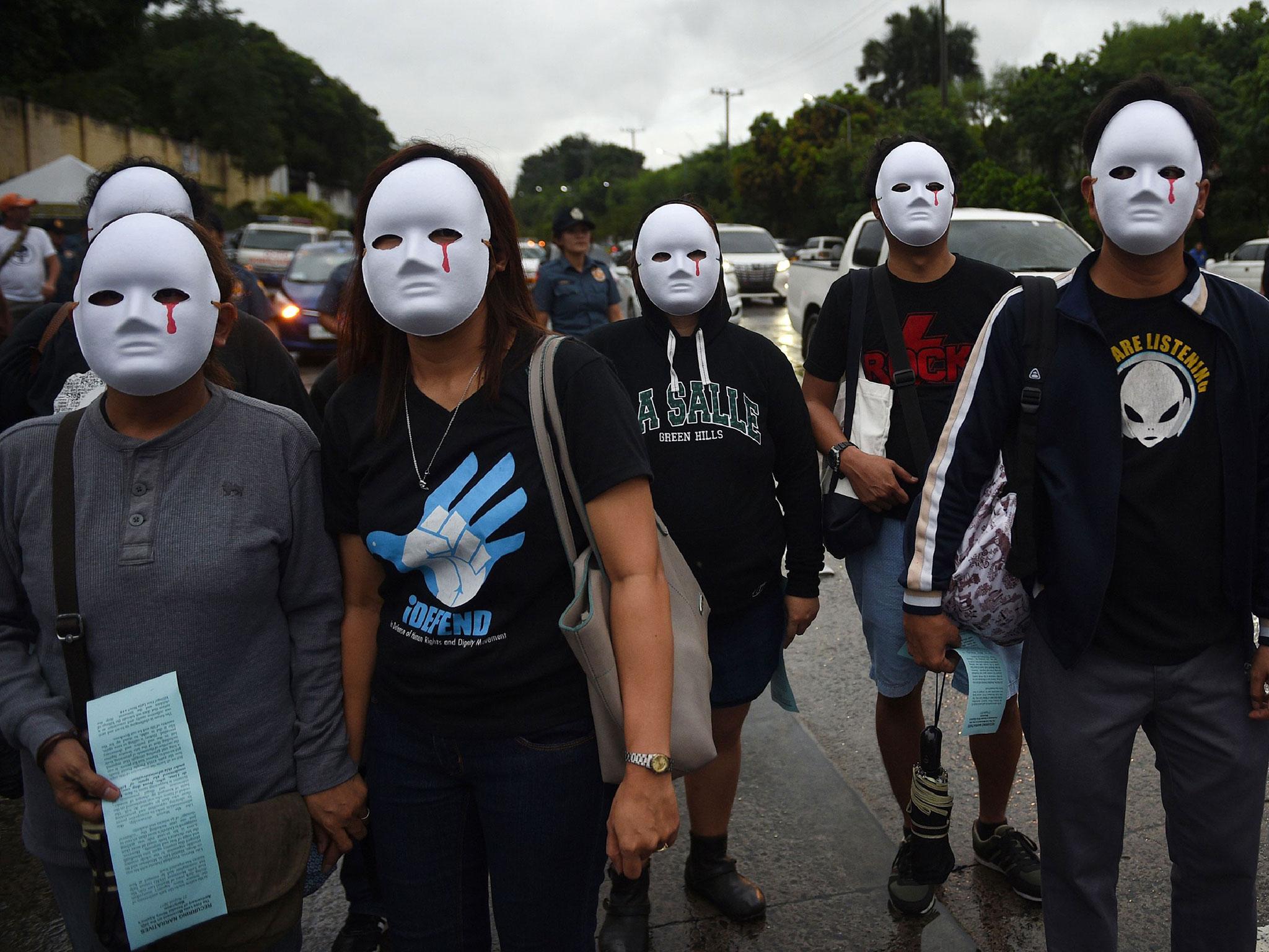 Protesters wearing masks depicting the victims of extra judicial killings taking part in a demonstration against the killings of suspected drug users allegedly by police during anti-drugs raids in Manila