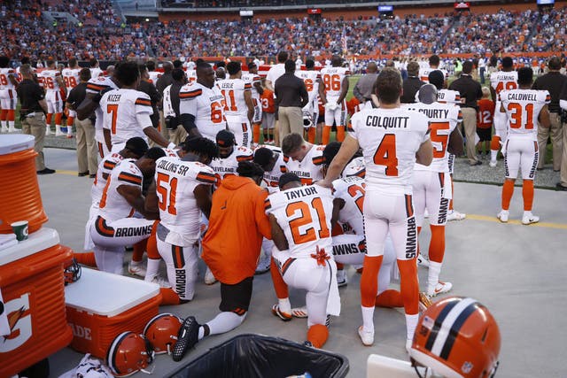Several Cleveland Browns players kneel in a circle in protest during the national anthem on 21 August 2017