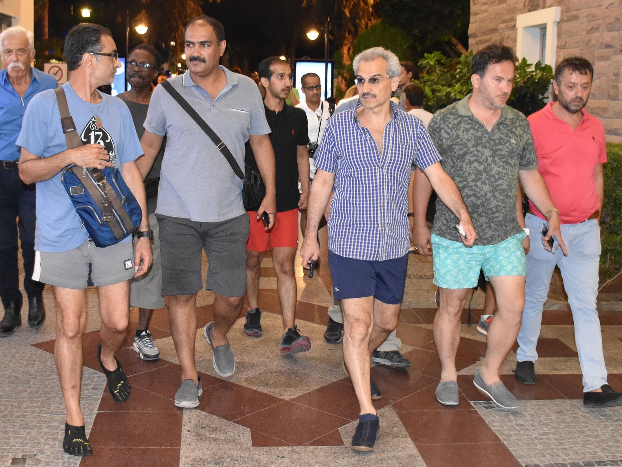 Saudi Prince Al-Waleed Bin Talal bin Abdulaziz al Saud (third on the right) arrives at a restaurant at Marina district with the advisor to the Turkish Prime Ministry, Taha Genc (second on the right) In Bodrum, Turkey