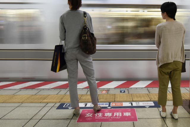 Women wait to board a women's-only carriage onboard a train on a subway station platform in Tokyo