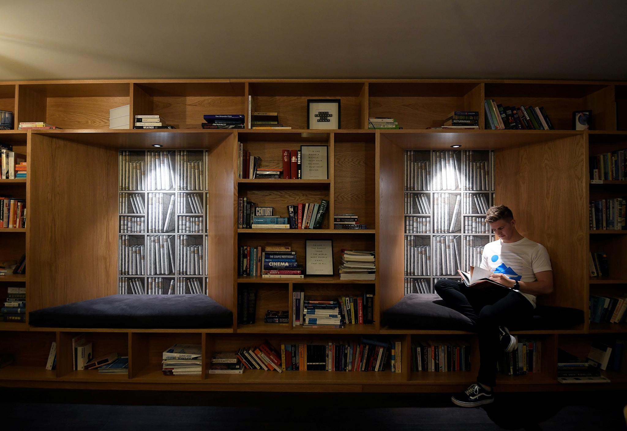 A resident relaxes in a communal library space