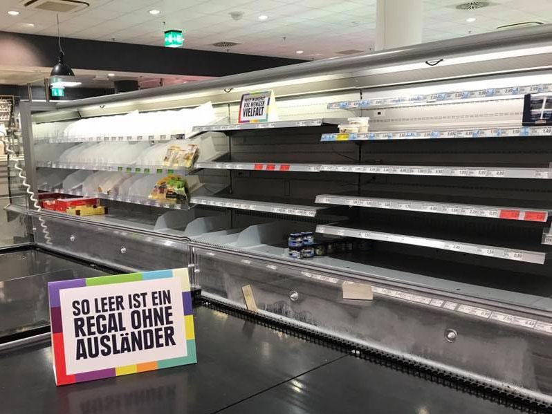 Empty shelves at the Edeka supermarket in Hamburg. The sign reads: 'So empty is a shelf without foreigners'