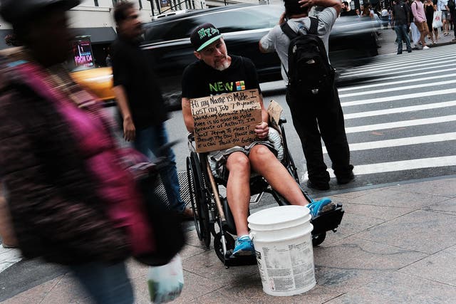 A man in New York City begs for money on a street corner
