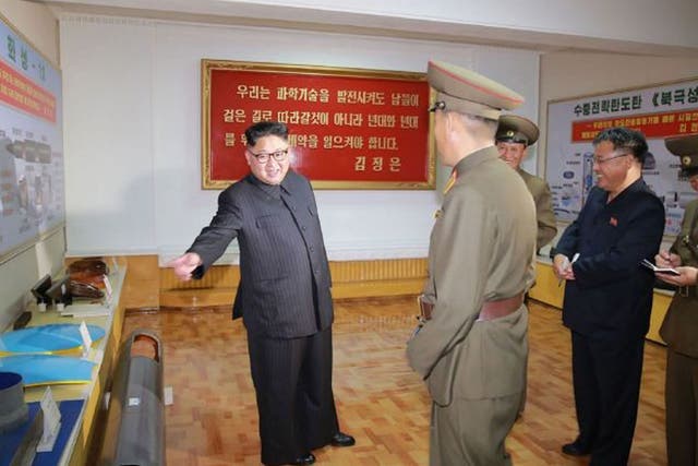 The undated picture shows Kim Jong-un surrounded by plans for new weapons