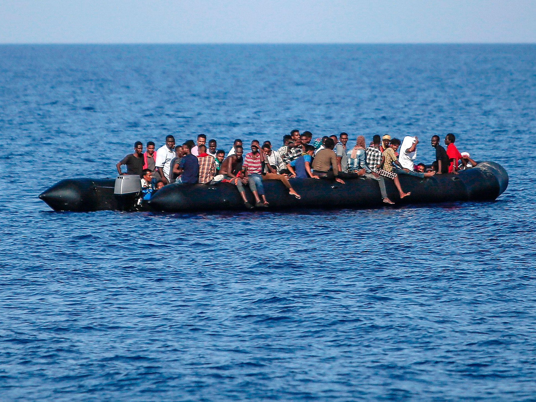 Migrants wait to be rescued by the Italian coast guard in the Mediterranean Sea, 30 nautical miles from the Libyan coast