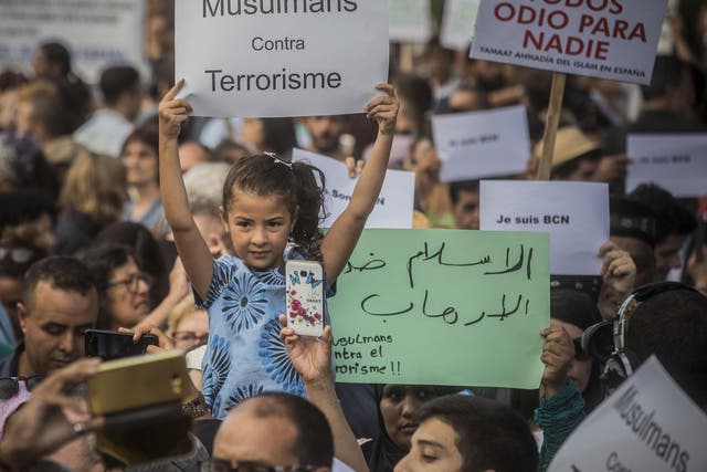 A girl holds a banner that reads: "Muslims Against Terrorism" during a protest by the Muslim community condemning the attack in Barcelona, Spain
