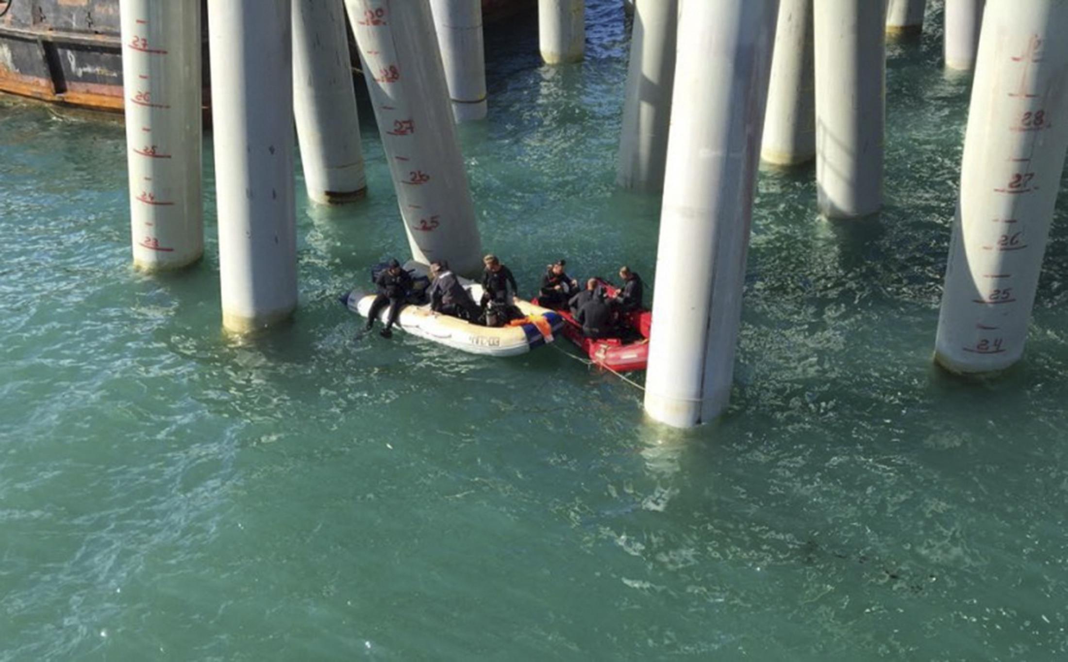 Rescuers work near a pier after a bus carrying a group of workers plunged into the Black Sea (Reuters)