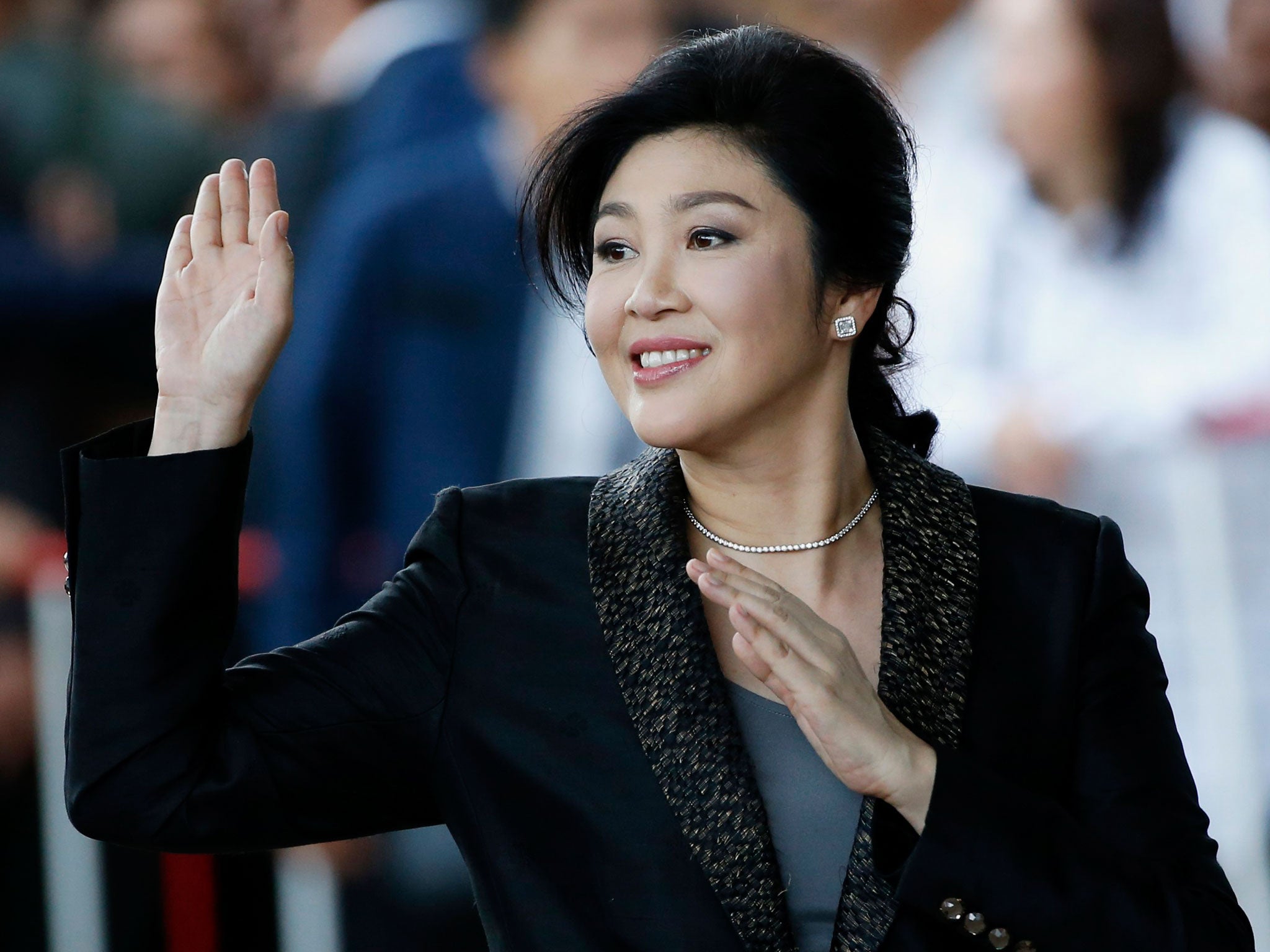 Yingluck Shinawatra waves to supporters as she arrives to deliver closing statements in her trial on 1 August