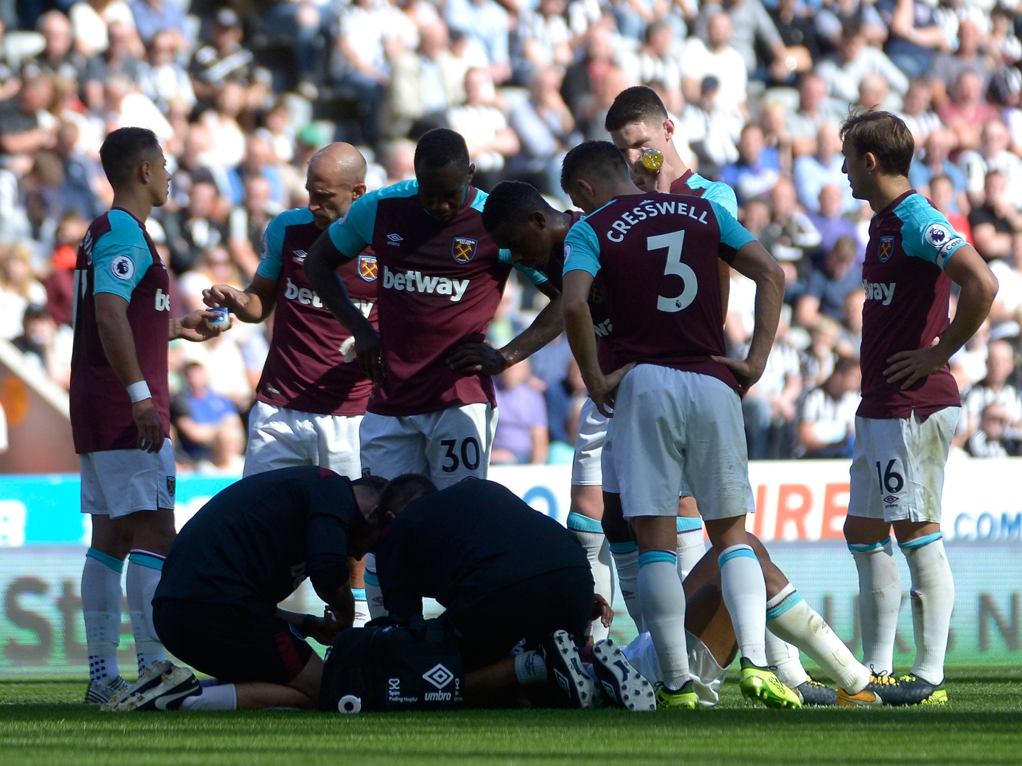 Andre Ayew receives treatment as his teammates look on