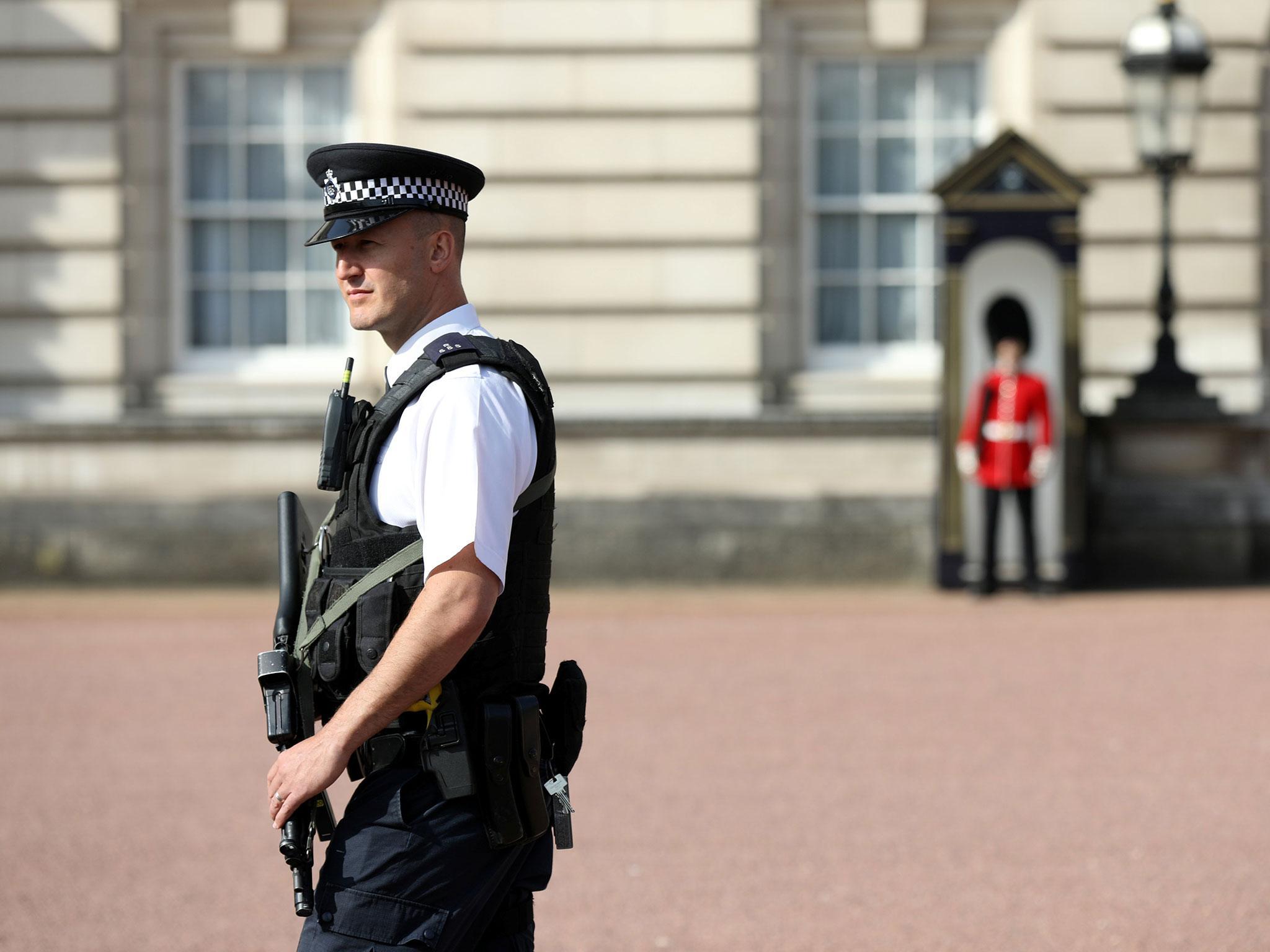 A police officer patrols within the grounds of Buckingham Palace in London